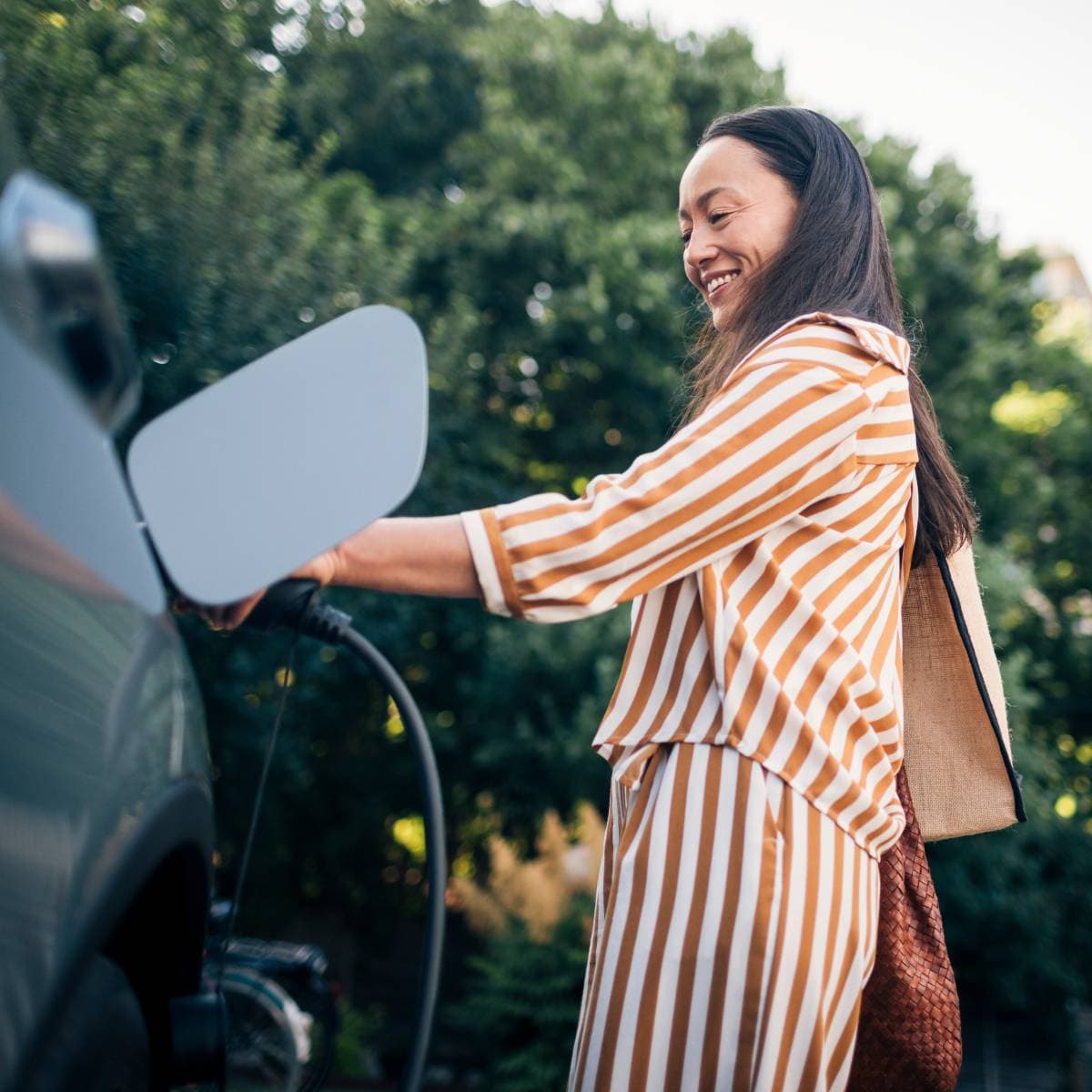 En kvinna laddar sin elbil.