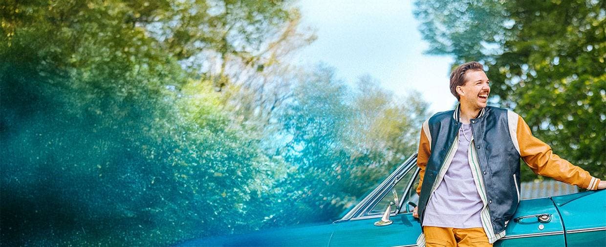 En man står vid en veteranbil.