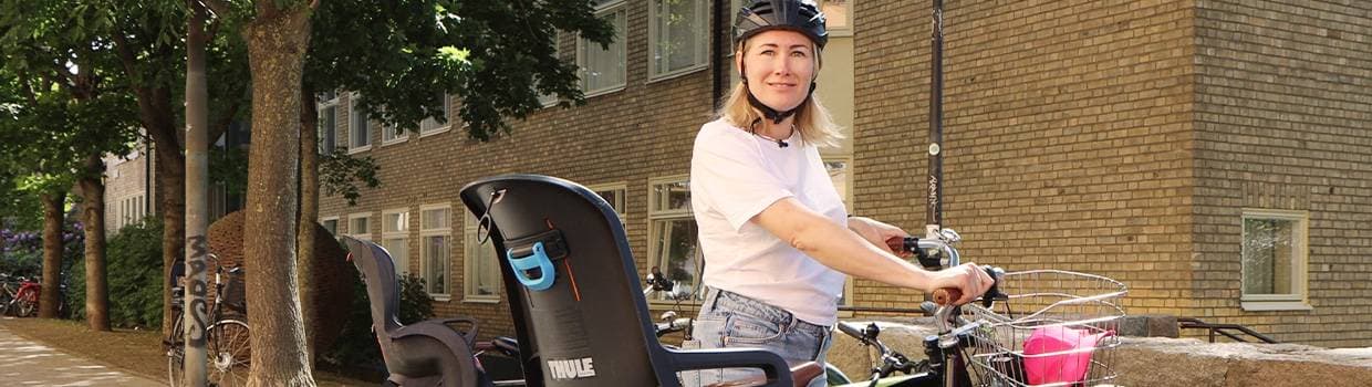 Kvinna som står och håller i cykel