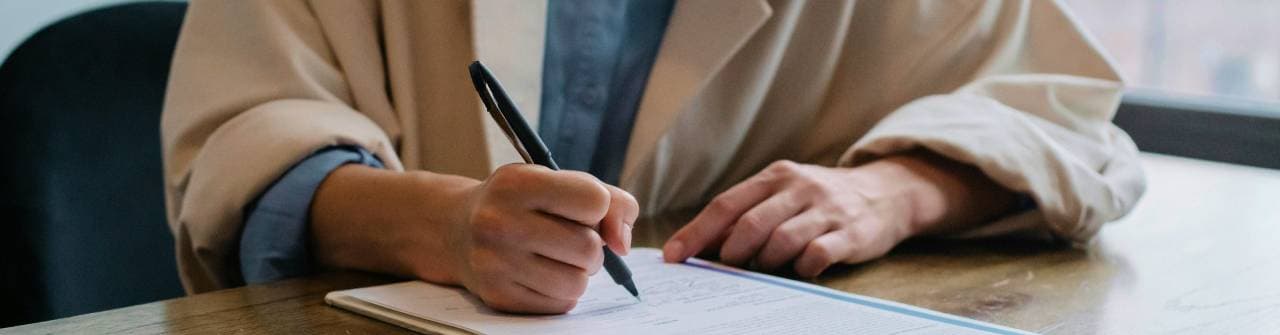 Person som skriver på ett papper.