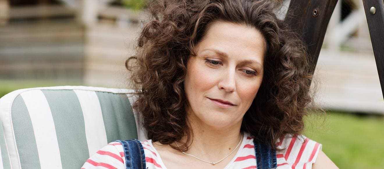 En kvinna sitter i en stol utomhus.