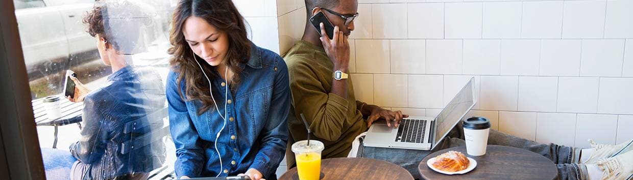 Kvinna och man som sitter på café och arbetar