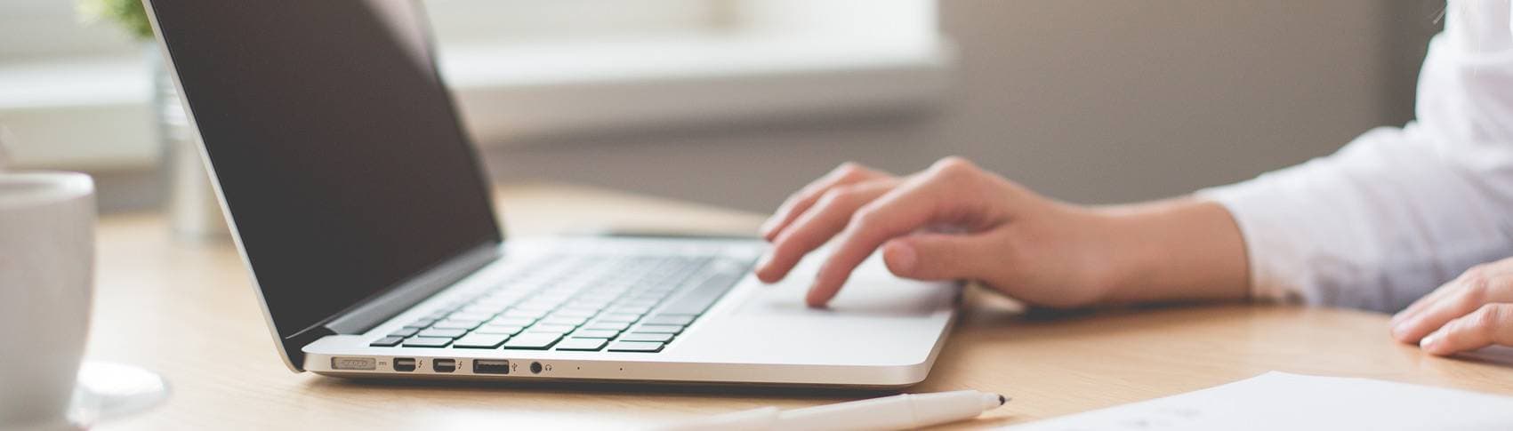 Hand som skriver på dator