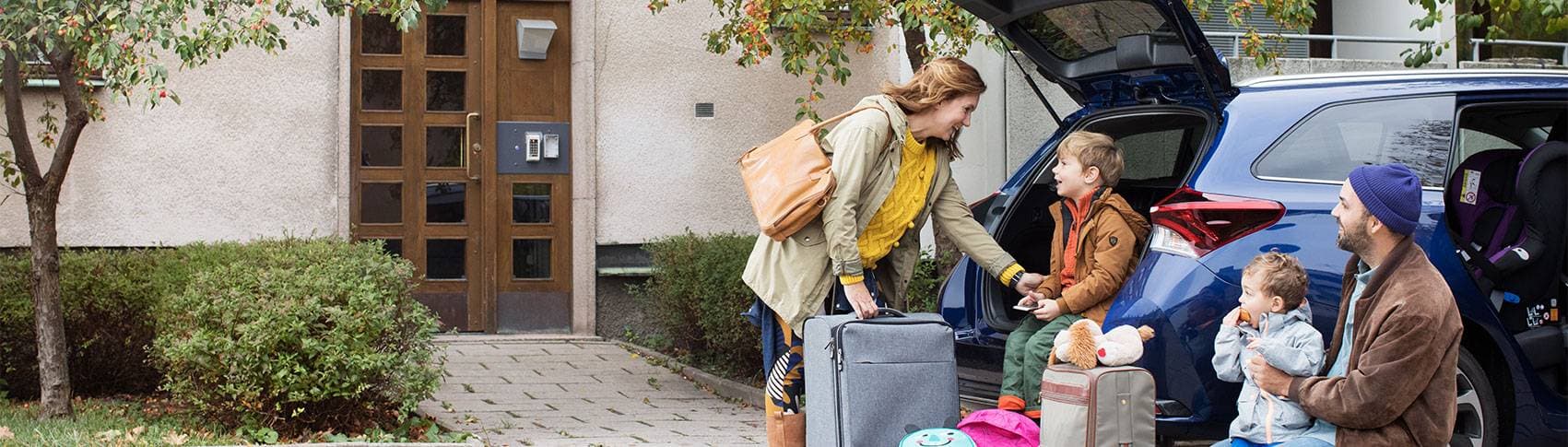 kvinna, man och två barn som packar en bil