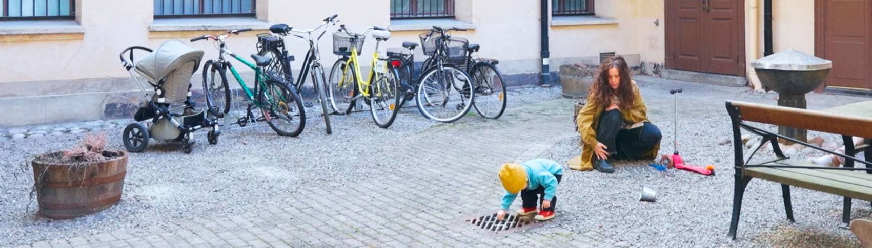 Mamma med barn och en barnvagn.