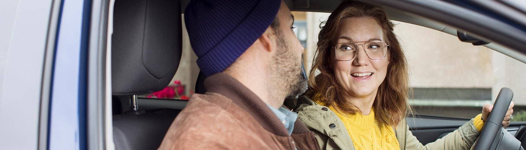 man och kvinna som sitter i bil