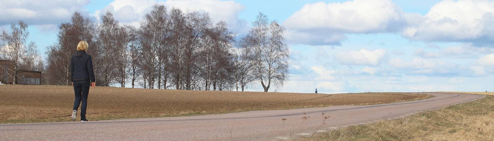 person som går längs landsväg