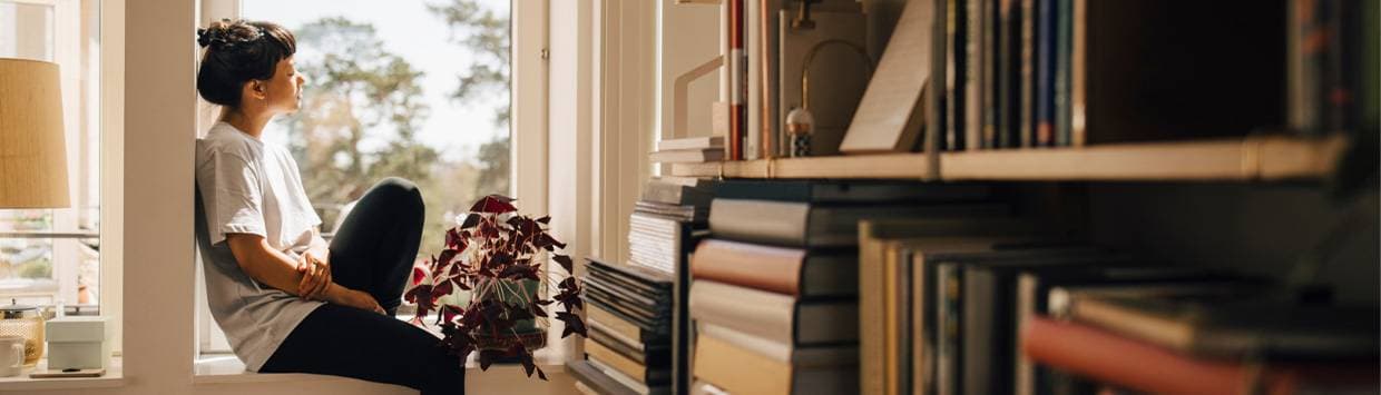 kvinna sitter i fönster